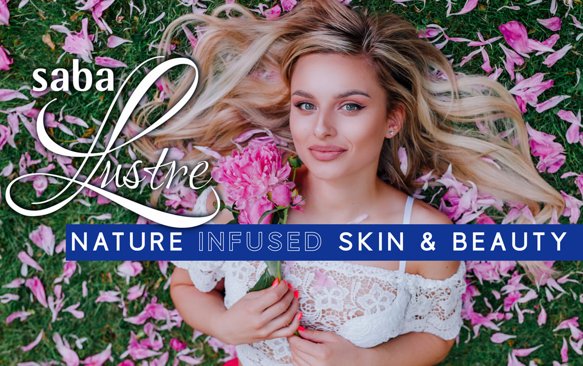 Woman lying on grass surrounded by pink petals holding flowers